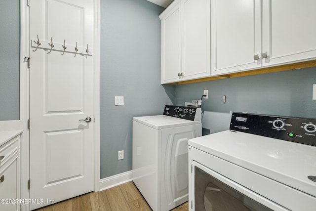 427 Ladyslipper Dr, Saint Johns, FL 32259 - clothes washing area featuring baseboards, separate washer and dryer, light wood-style floors, and cabinet space
