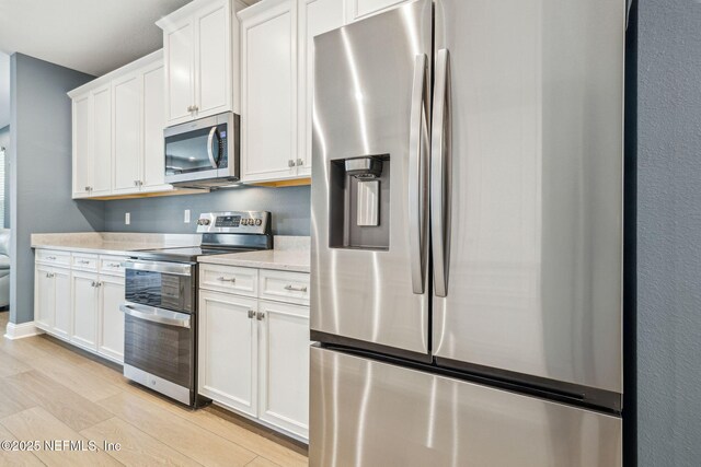 427 Ladyslipper Dr, Saint Johns, FL 32259 - kitchen featuring white cabinetry, light wood-style flooring, and stainless steel appliances