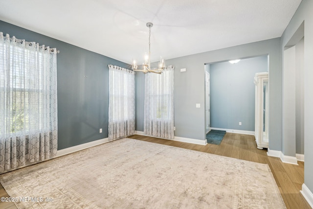 427 Ladyslipper Dr, Saint Johns, FL 32259 - spare room with baseboards, a notable chandelier, and wood finished floors