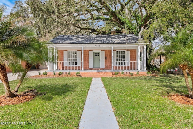 view of front of property featuring a front yard, a porch, and brick siding