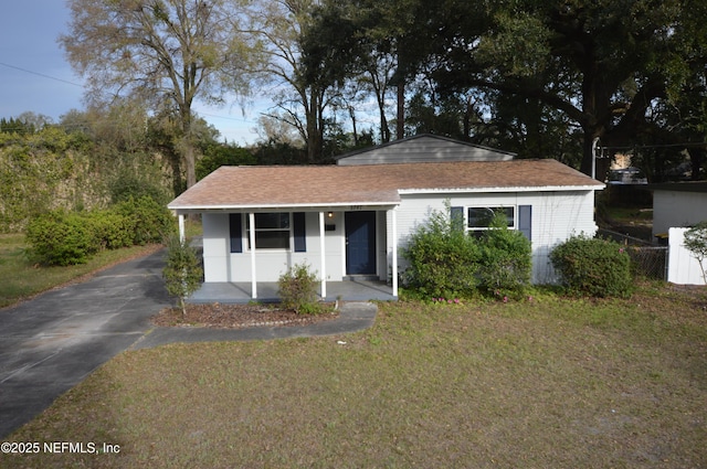 view of front of property with aphalt driveway, a front yard, and covered porch