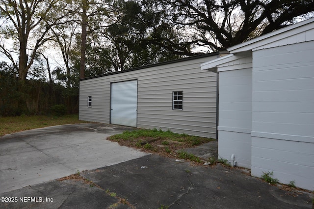 exterior space with concrete driveway and an outdoor structure