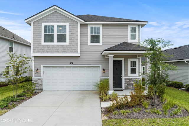 view of front facade with a garage, stone siding, a shingled roof, and concrete driveway