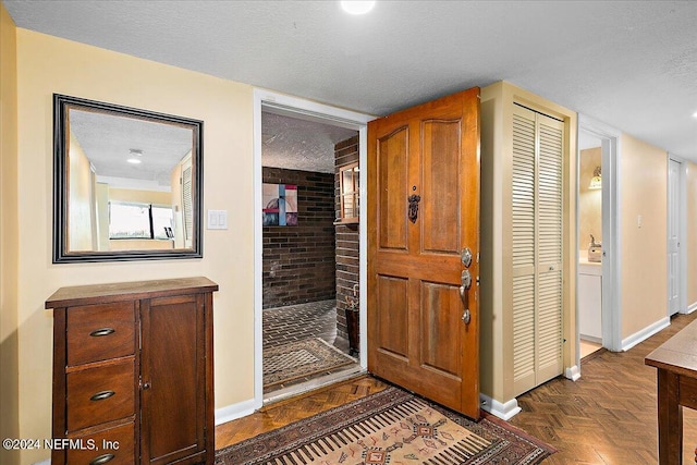 hallway featuring a textured ceiling and baseboards