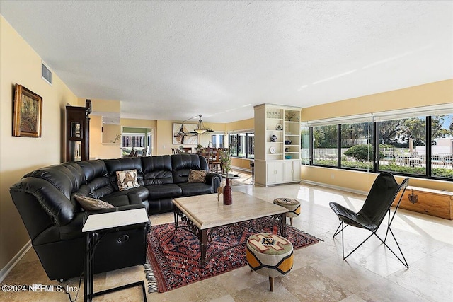 living room featuring a textured ceiling, visible vents, and baseboards