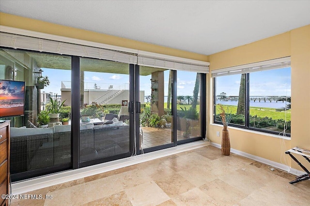 entryway featuring a water view and baseboards