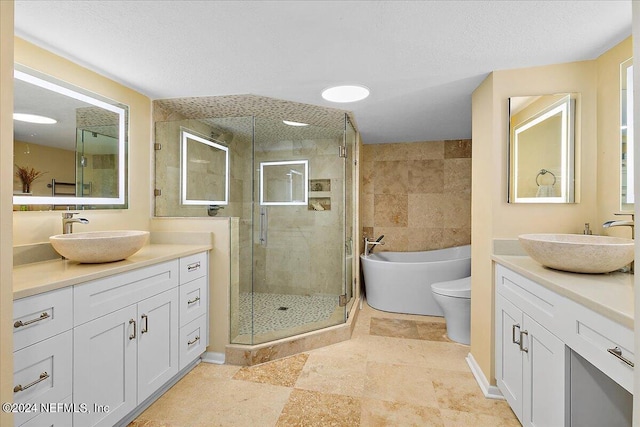 full bathroom featuring a stall shower, two vanities, and a sink