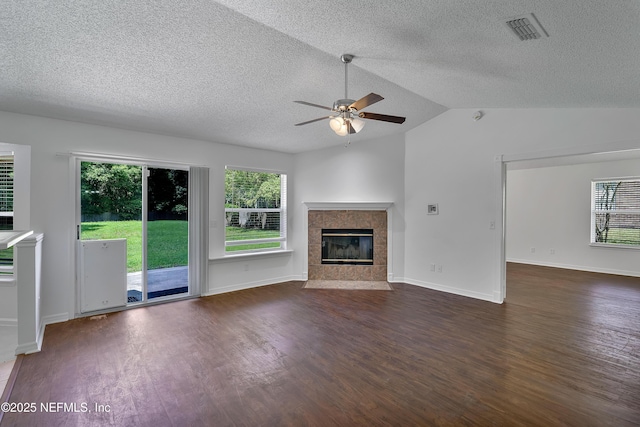 unfurnished living room with visible vents, a ceiling fan, dark wood-style floors, vaulted ceiling, and a high end fireplace