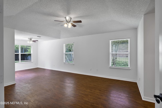 unfurnished room with dark wood-type flooring, ceiling fan, a textured ceiling, and baseboards