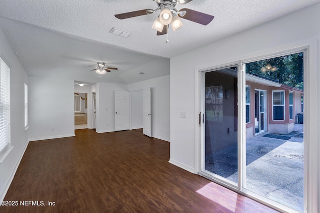 spare room with visible vents, dark wood finished floors, a textured ceiling, and baseboards