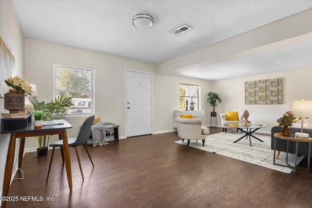 sitting room with a wealth of natural light, baseboards, visible vents, and wood finished floors