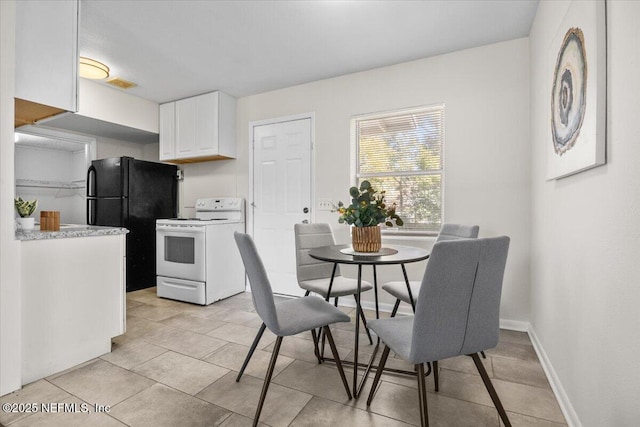 dining area featuring light tile patterned floors, visible vents, and baseboards