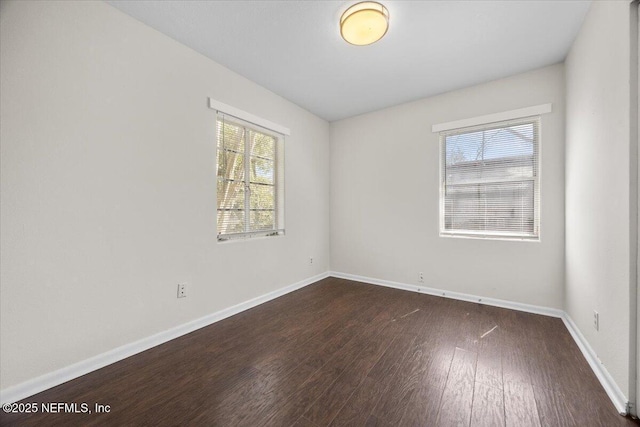 empty room with baseboards and dark wood-style flooring