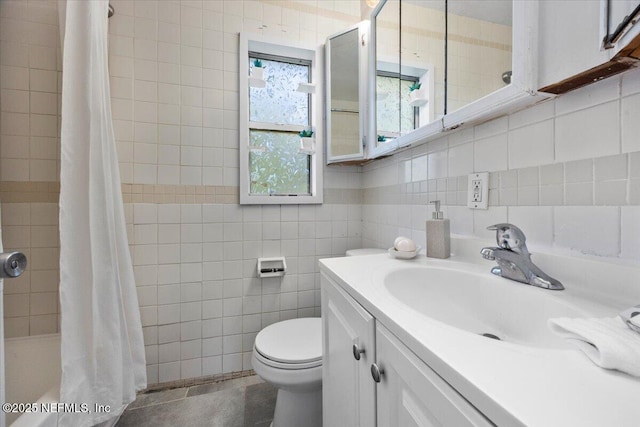 full bath with tile walls, tasteful backsplash, toilet, vanity, and tiled shower