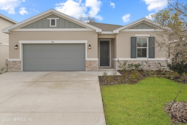 view of front of house featuring board and batten siding, stone siding, a garage, and concrete driveway