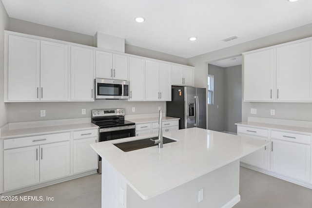 kitchen with stainless steel appliances, light countertops, a kitchen island with sink, and white cabinets