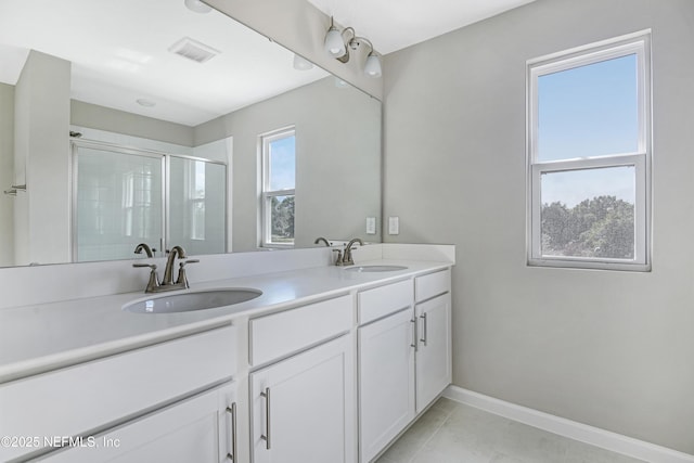 full bath featuring double vanity, a shower stall, visible vents, and a sink