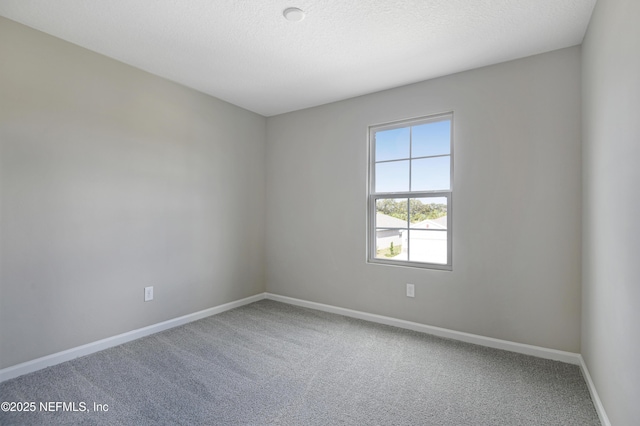 unfurnished room featuring carpet flooring, a textured ceiling, and baseboards