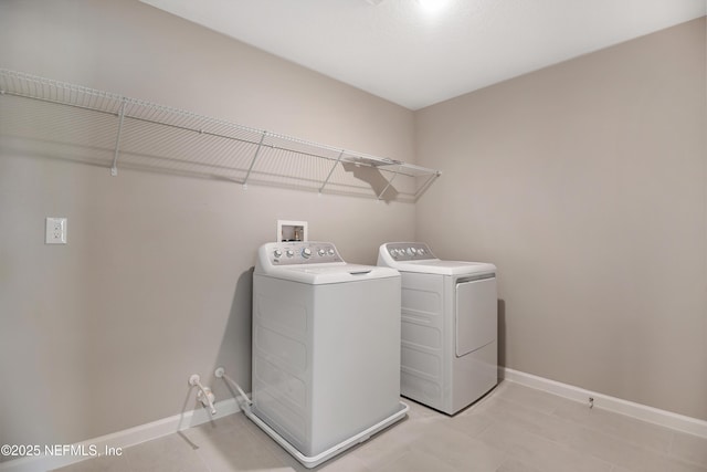 laundry area with laundry area, baseboards, and washer and clothes dryer