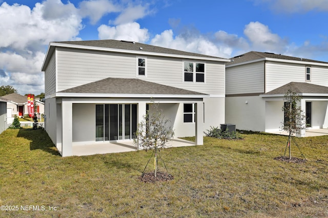 rear view of property featuring central air condition unit, a yard, and a patio