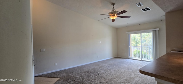 empty room featuring light carpet, baseboards, visible vents, vaulted ceiling, and a textured ceiling