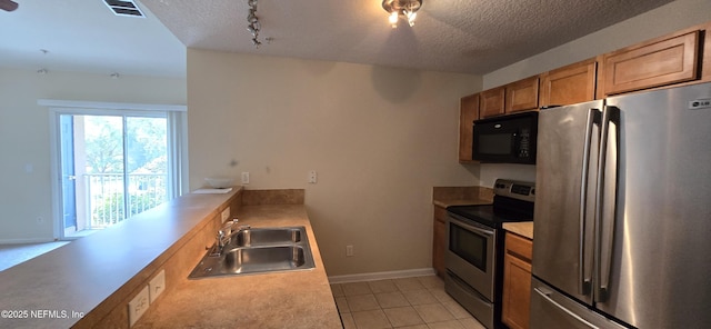 kitchen featuring appliances with stainless steel finishes, light countertops, a sink, and visible vents