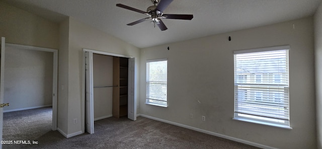 unfurnished bedroom with lofted ceiling, carpet, baseboards, and a closet