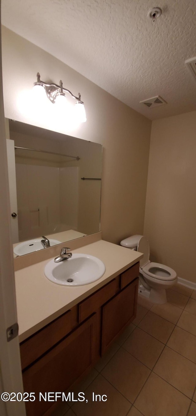 bathroom with visible vents, toilet, tile patterned floors, a textured ceiling, and vanity