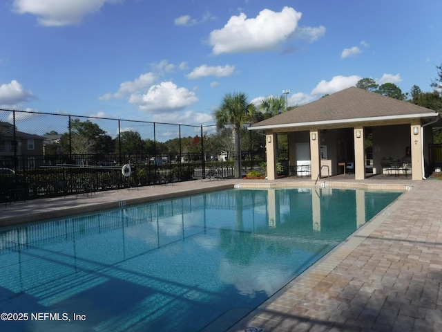 pool with a patio and fence