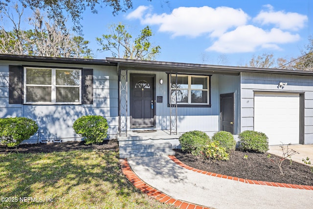 ranch-style home featuring a garage, driveway, and a front lawn