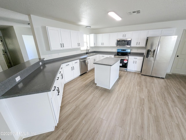 774 Barrington Dr, Fernandina Beach, FL 32034 - kitchen featuring appliances with stainless steel finishes, a sink, light wood finished floors, white cabinetry, and visible vents