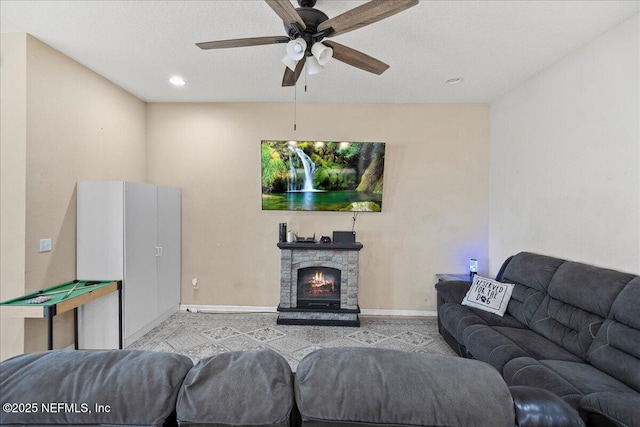 living area with recessed lighting, a fireplace, a ceiling fan, and baseboards