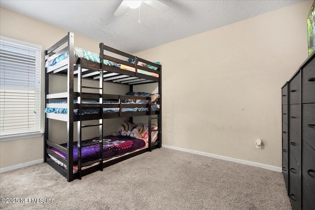 bedroom featuring carpet floors, a ceiling fan, baseboards, and a textured ceiling