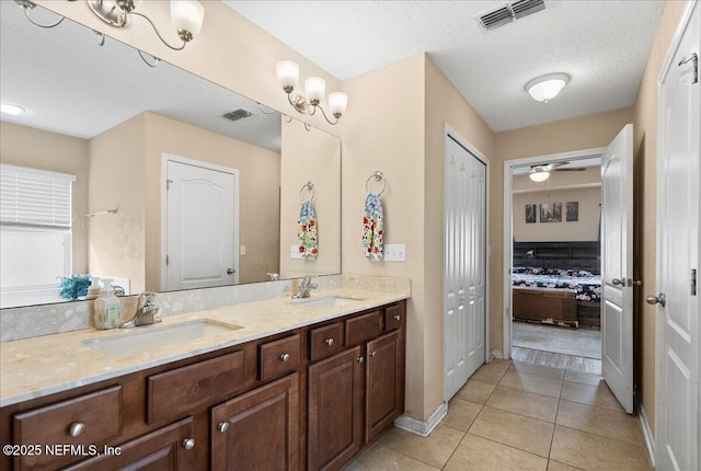 bathroom featuring visible vents, a sink, and tile patterned floors