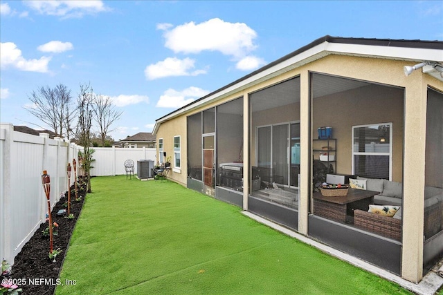 view of yard featuring a sunroom, a fenced backyard, outdoor lounge area, and cooling unit