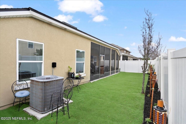 view of yard featuring a fenced backyard, a sunroom, and central air condition unit