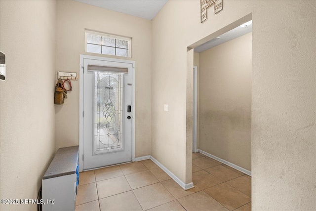 entrance foyer featuring light tile patterned flooring and baseboards