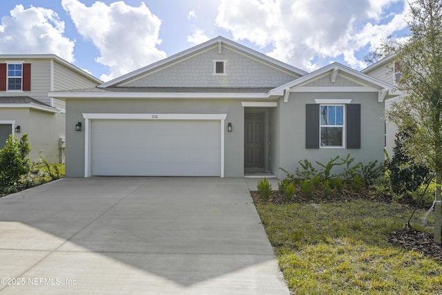 view of front facade featuring an attached garage, driveway, and stucco siding