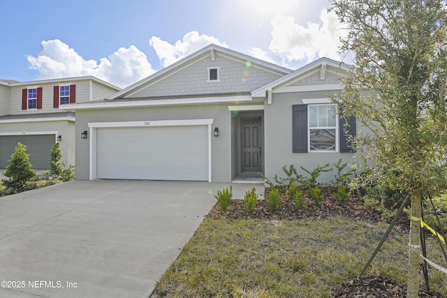 view of front facade with a garage, concrete driveway, and stucco siding