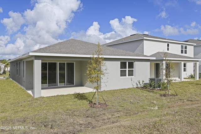 back of property with a yard, stucco siding, a shingled roof, a patio area, and cooling unit