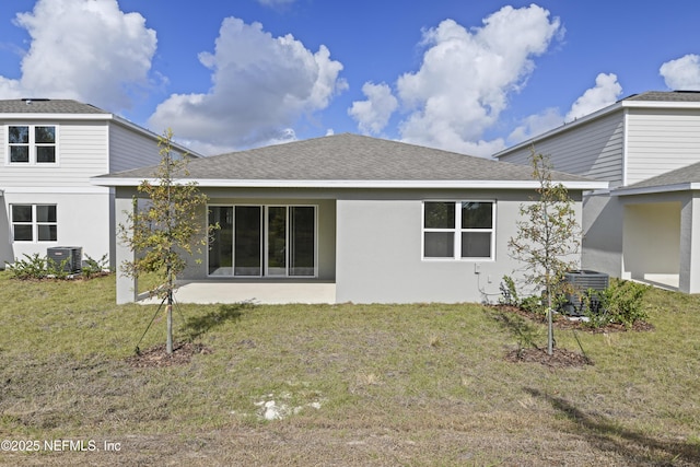 back of property featuring roof with shingles, a lawn, stucco siding, and central air condition unit