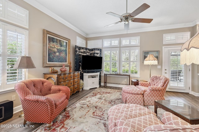 living room featuring plenty of natural light, crown molding, and wood finished floors