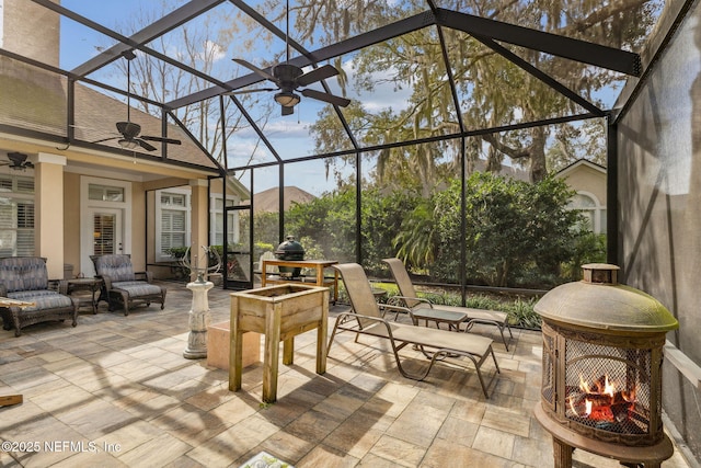 view of patio / terrace with glass enclosure, ceiling fan, and an outdoor living space