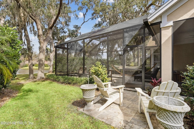 view of yard featuring glass enclosure and a patio