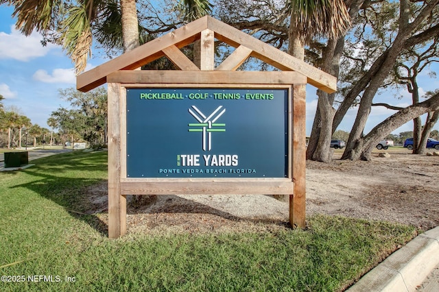 community / neighborhood sign with a yard