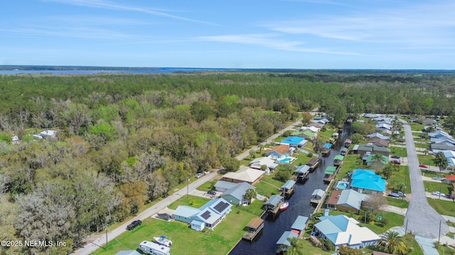 drone / aerial view with a wooded view and a residential view