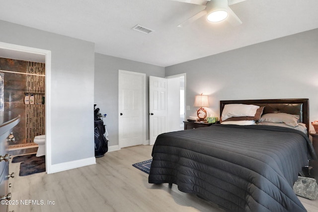 bedroom featuring baseboards, visible vents, a ceiling fan, wood finished floors, and ensuite bathroom