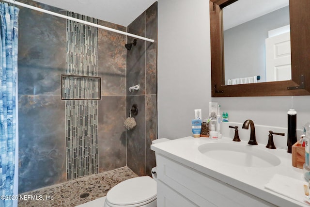 full bathroom featuring a stall shower, vanity, and toilet