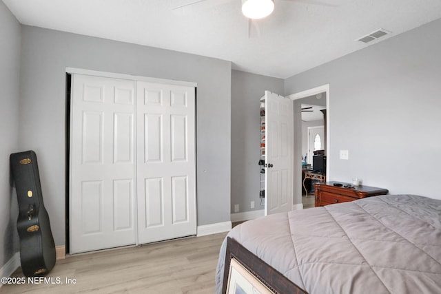 bedroom with a closet, visible vents, light wood-style floors, ceiling fan, and baseboards