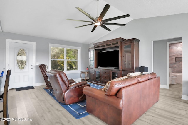 living room with vaulted ceiling, ceiling fan, light wood-style flooring, and baseboards